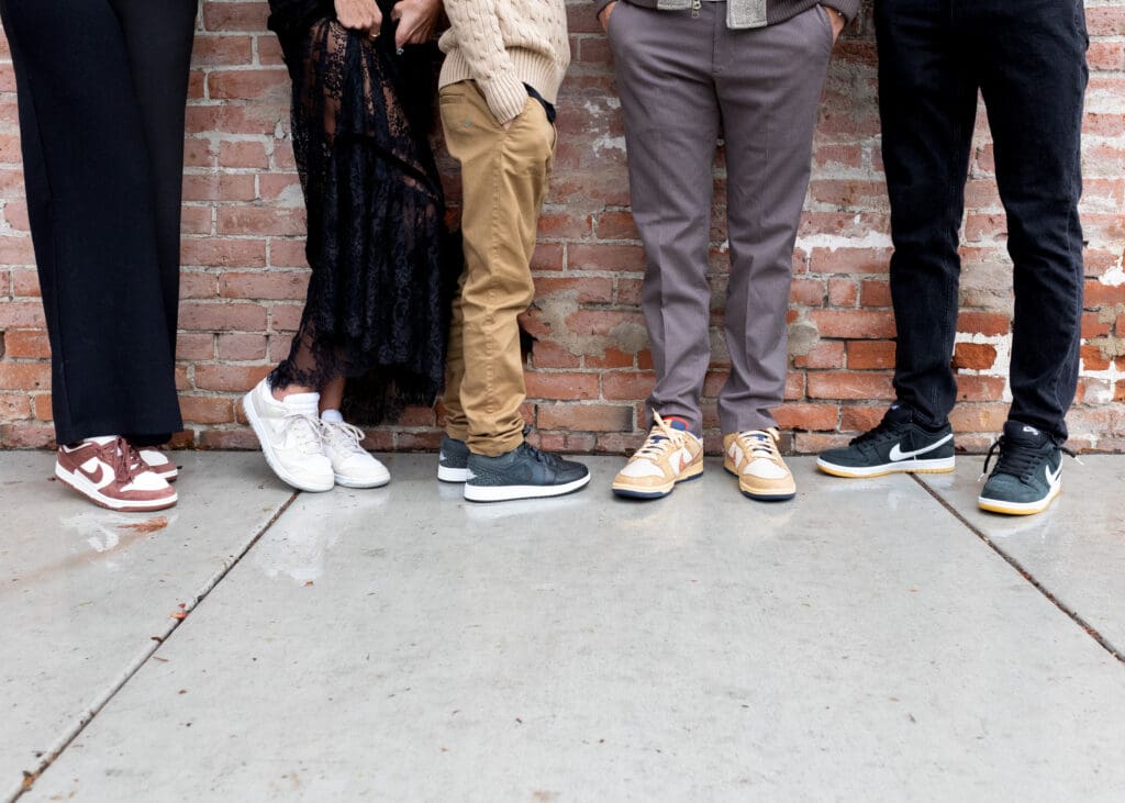 Casual sneakers and outfits against brick wall, showing personality and style in modern family photos at home.