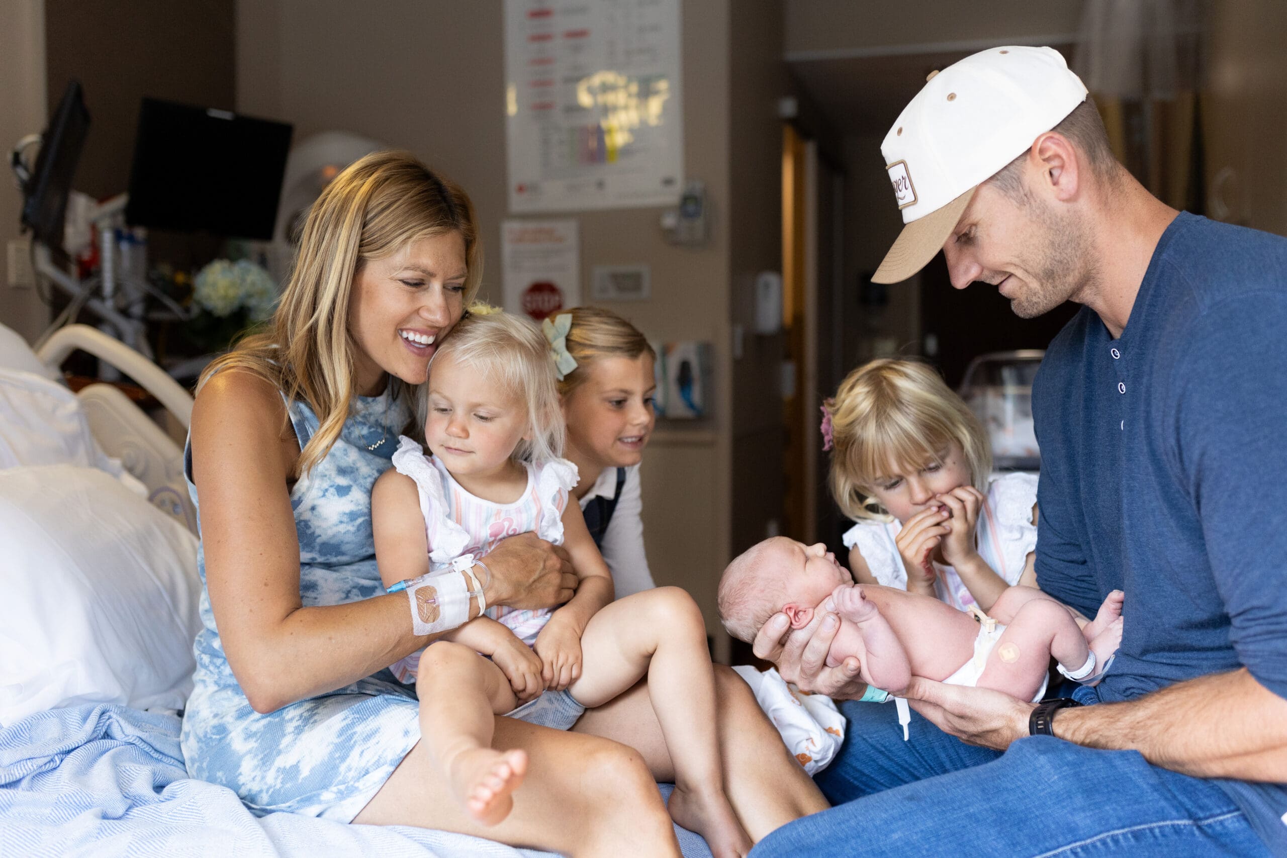questions to ask a photographer before you book - mom and dad introducing a baby to their siblings