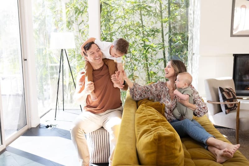 Timeless photography of joyful family playing together in bright, natural light at home.